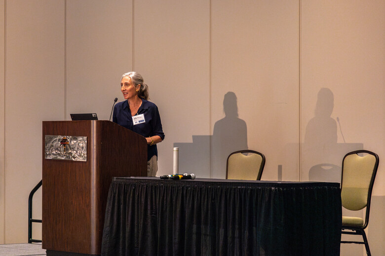 A speaker delivering a keynote from the podium at ICSR 2024